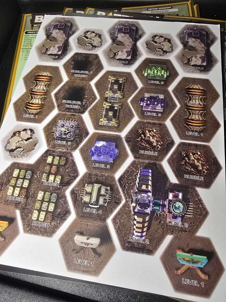 A sheet of punch-out cardboard hexes with buildings on them
